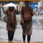 women walking in the rain with umbrellas